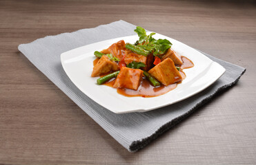 deep fried bean curd tofu with spicy sambal chilli sauce on wood background asian halal vegan menu