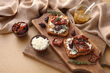 Tasty bruschettas with cheese, sun-dried tomatoes and dates on color background, closeup