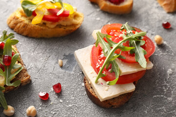 Tasty bruschettas on grunge background, closeup