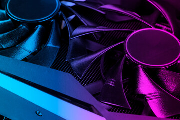 Video card with fan in blue and pink tones. Gaming graphics card for video games and cryptocurrency mining. Game video card. background. Electronic device, computer part. GPU card