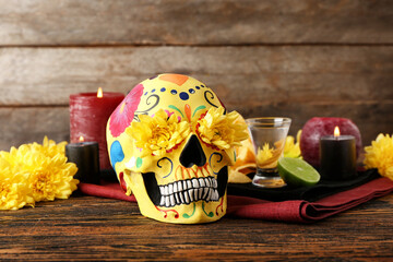 Painted human skull for Mexico's Day of the Dead (El Dia de Muertos), flowers, candles and tequila...