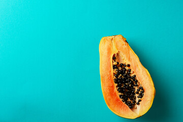 Summer composition. Tropical papaya fruits cut in half lie on a blue background. Summer concept. Flat lay, top view, copy space