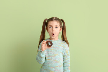 Little girl with letter O on color background
