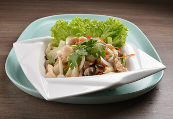 thai cold mushroom vegetable salad in spicy sour lime sauce on wood background asian halal vegan menu