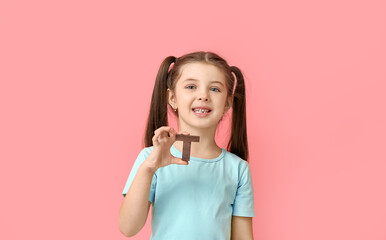 Little girl with letter T on color background