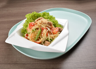 thai cold mango papaya vegetable salad in spicy sour lime sauce on wood background asian halal vegan menu