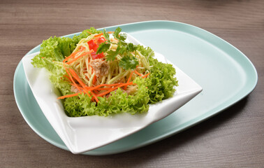 thai cold mango papaya vegetable salad in spicy sour lime sauce on wood background asian halal vegan menu