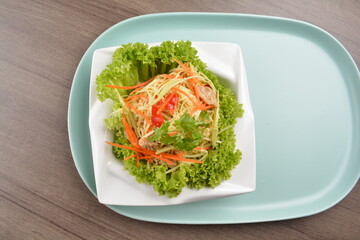 thai cold mango papaya vegetable salad in spicy sour lime sauce on wood background asian halal vegan menu