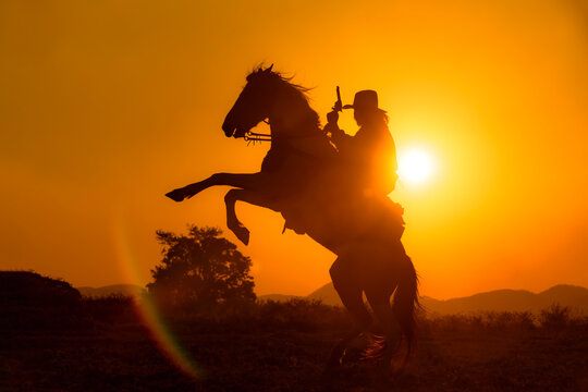 Cowboy silhouette riding a horse When the sunset looks beautiful
