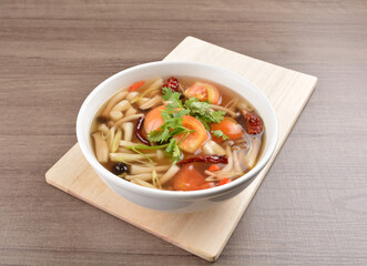 cook hot and spicy tom yum soup with mushroom and mixed vegetables in white bowl on wood background asian halal vegan menu