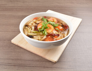 cook hot and spicy tom yum soup with mushroom and mixed vegetables in white bowl on wood background asian halal vegan menu