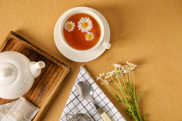 Composition with tasty chamomile tea and flowers on color background