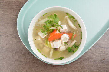 healthy white bean curd tofu and mixed vegetable hot soup on wood background asian halal vegan menu