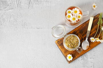 Obraz na płótnie Canvas Composition with cup of chamomile tea and dried flowers on grunge background