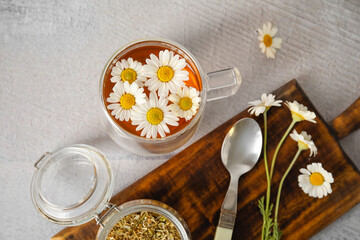 Composition with cup of chamomile tea and dried flowers on grunge background
