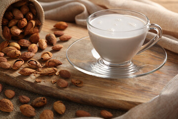 Close up Almond milk in the glass with some almonds on wooden table background. Healthy foods concept.