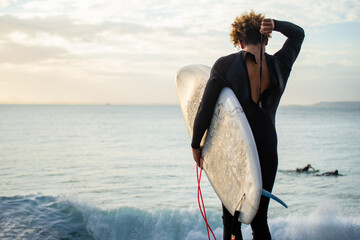 Rear View of Surfer Closing Wetsuit Before Jump to the Water. Water Sport Concept. Copy Space