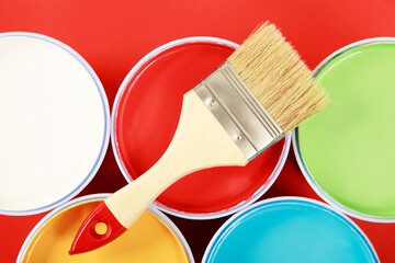 The cans of interior wall paint is placed on a red background.