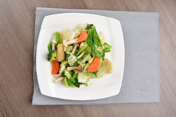 stir fried mixed vegetable and carrot in soy sauce on wood background asian halal vegan menu
