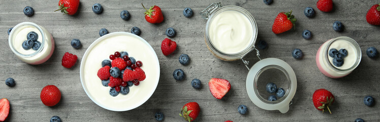 Concept of tasty breakfast with yogurt on gray textured table