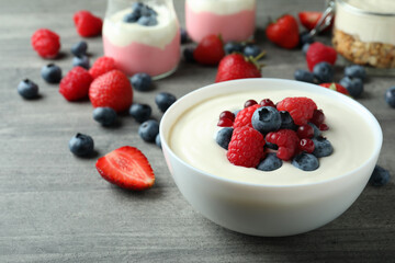 Concept of tasty breakfast with yogurt on gray textured table