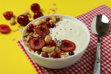 Concept of tasty breakfast with yogurt on yellow background