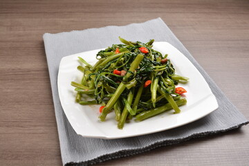 stir fried spicy sambal chilli sauce kang kong vegetables on wood background asian halal vegan menu
