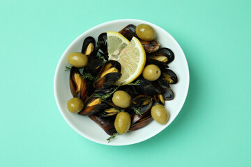 Bowl of mussels with spices on mint background