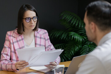 interview or negotiation, a successful and beautiful business woman in her office interviewing a man or discussing a work plan with a colleague or subordinate, hr specialist or psychologist