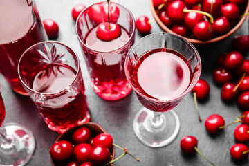 Composition with glasses of sweet cherry wine on dark background, closeup