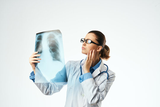 female medical professional in a white coat looking at an x-ray to a professional