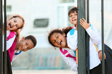 Cute little pupils near school entrance outdoors