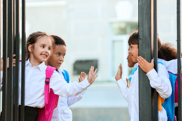 Cute little pupils near school entrance outdoors