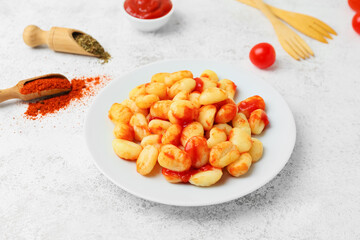 Plate with tasty gnocchi on grunge background