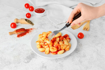 Woman eating tasty gnocchi from plate