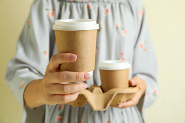 Woman holds holder with paper coffee cups
