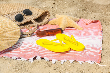 Stylish flip-flops and beach accessories on sand