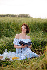 Beautiful young woman in summer in a wheat field