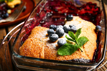 Baking dish with blueberry cobbler on table, closeup