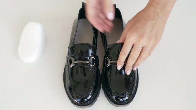 A young girl is preparing for the start of the school year and unpacking new shiny black loafers. 