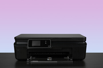 Home laser printer on desk against purple background