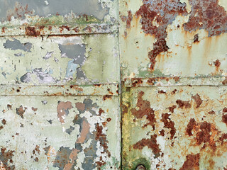 old texture of painted metal door or wall with rusty, cracked and peeling paint
