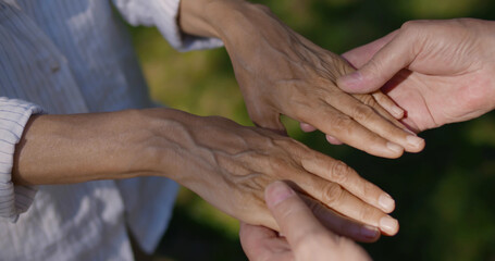 Top view of mature husband and wife hold hands outdoors
