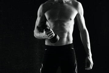 Fototapeta na wymiar sporty man with dumbbells in hands pumping up muscles exercises dark background