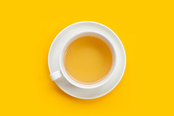 Obraz na płótnie Canvas White cup of tea on yellow background