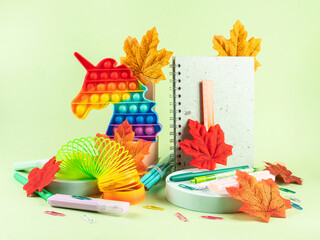 Colorful stationery copybooks set on green with autumn leaves. Back to school