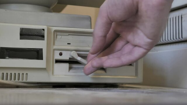 The inserting an old-style 5.25, 3.5 Inch floppy disks. 
Old-style 1980s - 1990s computer