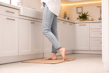 Woman standing on rug in kitchen, closeup