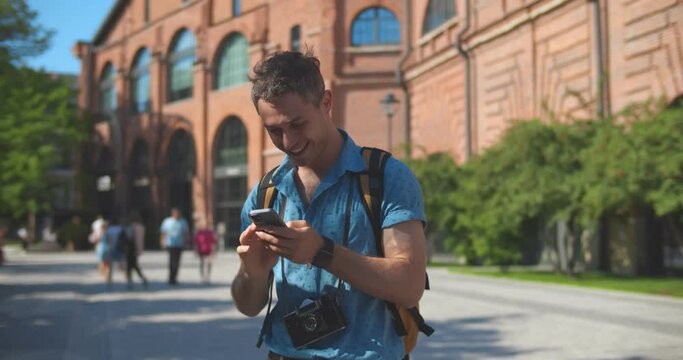 Caucasian tourist man smiling happy using smartphone at summer city abroad