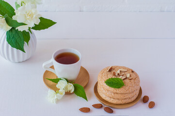 Useful Lenten cookies from almond flour stacked on white wooden background wuth cup of jasmine tea. selective focus